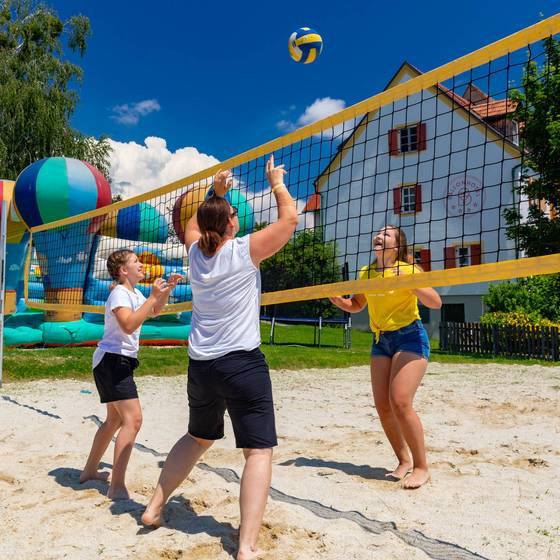 Mutter spielt mit ihren beiden Töchtern Volleyball auf einem Sandplatz (FamilienUrlaub Steiermark, Foto: Harry Schiffer)