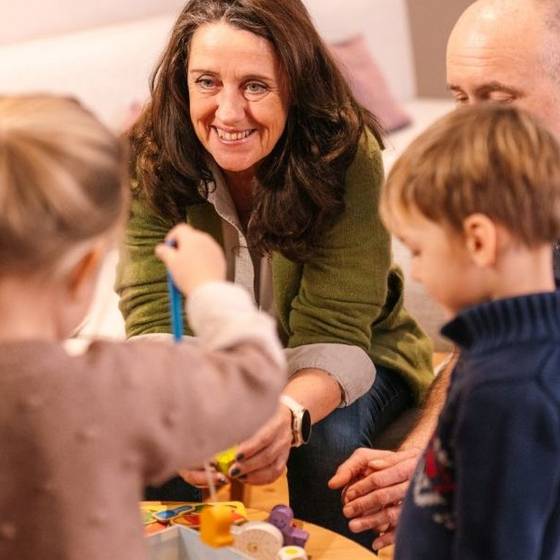 Oma, Opa und zwei Enkelkinder sitzen um einen Tisch und spielen ein Brettspiel. Oma, Opa und zwei Enkelkinder sitzen um einen Tisch und spielen ein Brettspiel.