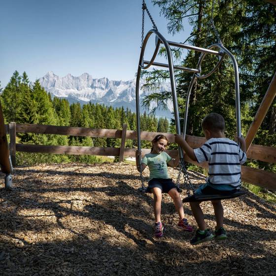 Zwei Kinder auf der Schaukel am Erlebnisspielplatz (Foto: Jakob Ertl).