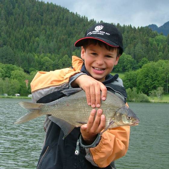 Petri Heil - Kind mit Fisch am Putterersee (Foto: Puttererseehof)