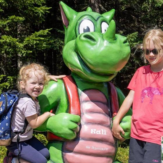 Zwei Mädchen mit Kali, dem Maskottchen vom Rittiberg (grüner Drache)