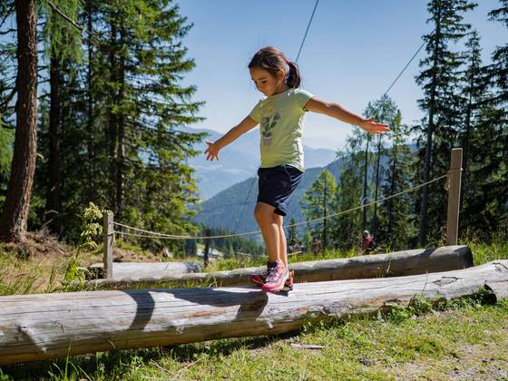 Ein Mädchen balanciert über einen Baumstamm (Foto: Jakob Ertl).
