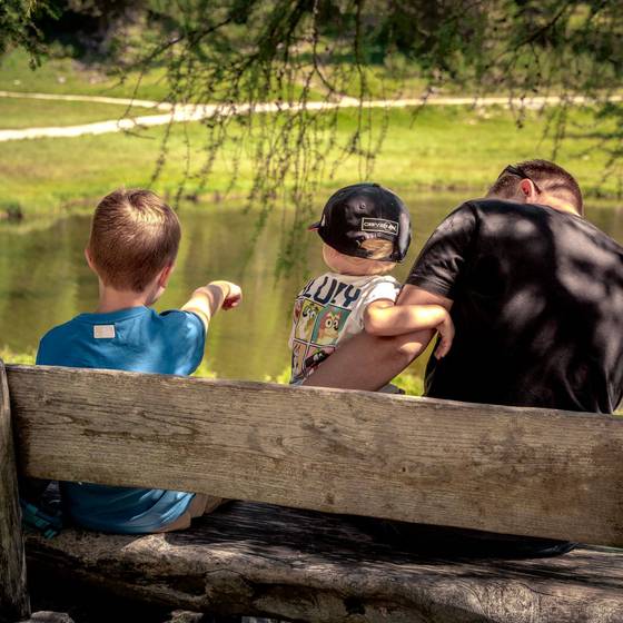 Veter und zwei Kinder sitzend auf einer Bank (Foto: needful.at)