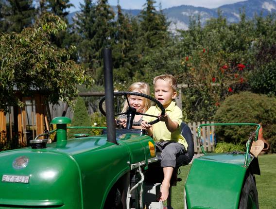 Kinder auf grünem Oldtimer-Traktor (Foto: Herbert Raffalt)