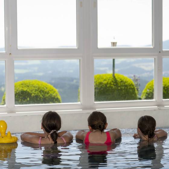 3 Mädchen von hinten im Pool, blicken aus dem Fenster