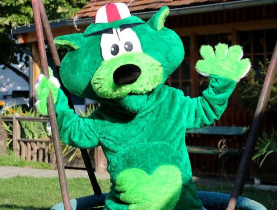 Panther-Pankratz, das Maskottchen von FamilienUrlaub Steiermark, winkend auf der Schaukel (FamilienUlraub-Steiermark, Foto: Tierwelt-Herberstein